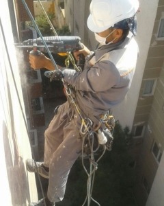 در حال پیچ ورولپلاک زدن سنگ نما با دریل مخصوص